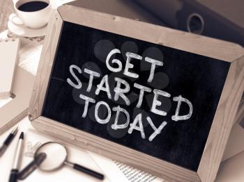 Get Started Today Handwritten by White Chalk on a Blackboard. Composition with Small Chalkboard on Background of Working Table with Office Folders, Stationery, Reports. Blurred, Toned 3d Image.