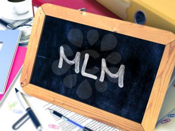 Handwritten MLM - Multi Level Marketing - on a Chalkboard. Composition with Chalkboard and Ring Binders, Office Supplies, Reports on Blurred Background. Toned Image. 3D Render.