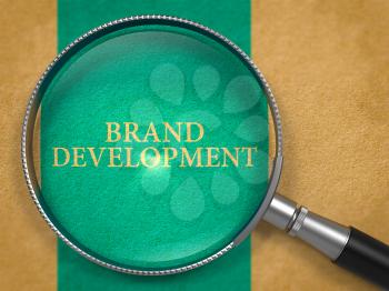 Brand Development through Lens on Old Paper with Blue Vertical Line Background. 3D Render.