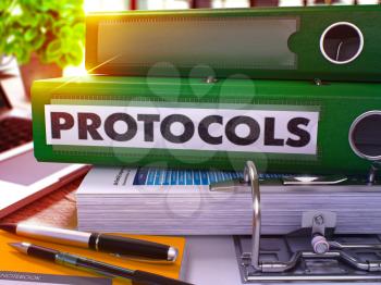 Protocols - Green Office Folder on Background of Working Table with Stationery and Laptop. Protocols Business Concept on Blurred Background. Protocols Toned Image. 3D.