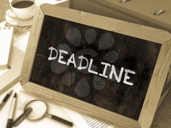 Deadline Handwritten by White Chalk on a Blackboard. Composition with Small Chalkboard on Background of Working Table with Office Folders, Stationery, Reports. Blurred, Toned Image. 3D Render.