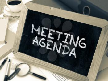 Meeting Agenda Concept Hand Drawn on Chalkboard on Working Table Background. Blurred Background. Toned Image. 3D Render.