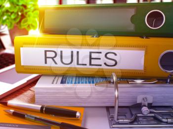 Rules - Yellow Office Folder on Background of Working Table with Stationery and Laptop. Rules Business Concept on Blurred Background. Rules Toned Image. 3D.