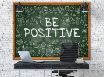 Be Positive Concept Handwritten on Green Chalkboard with Doodle Icons. Office Interior with Modern Workplace. White Brick Wall Background. 3D.