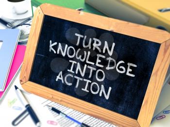 Turn Knowledge into Action Handwritten on Chalkboard. Composition with Small Chalkboard on Background of Working Table with Ring Binders, Office Supplies, Reports. Blurred, Toned Image. 3D Render.