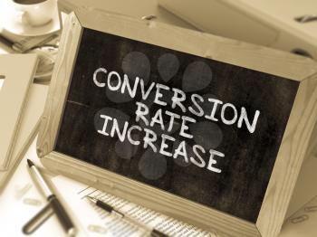 Conversion Rate Increase Handwritten on Chalkboard. Composition with Small Chalkboard on Background of Working Table with Ring Binders, Office Supplies, Reports. Blurred, Toned Image. 3D Render.
