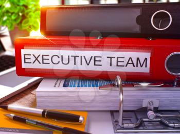 Executive Team - Red Office Folder on Background of Working Table with Stationery and Laptop. Executive Team Business Concept on Blurred Background. Executive Team Toned Image. 3D.