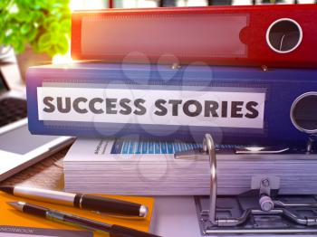 Success Stories - Blue Office Folder on Background of Working Table with Stationery and Laptop. Success Stories Business Concept on Blurred Background. Success Stories Toned Image. 3D.