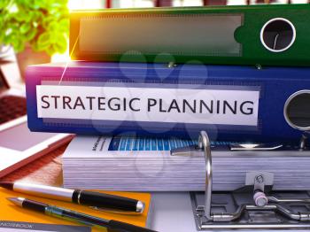 Strategic Planning - Blue Office Folder on Background of Working Table with Stationery and Laptop. Strategic Planning Business Concept on Blurred Background. Strategic Planning Toned Image. 3D.