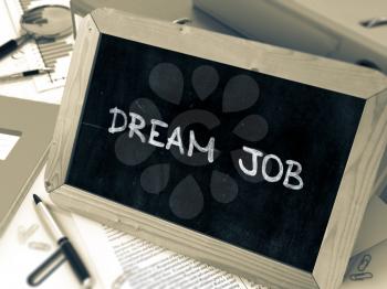 Dream Job Handwritten on Chalkboard. Composition with Small Chalkboard on Background of Working Table with Ring Binders, Office Supplies, Reports. Blurred Background. Toned Image. 3D Render.