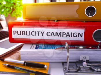 Publicity Campaign - Red Office Folder on Background of Working Table with Stationery and Laptop. Publicity Campaign Business Concept on Blurred Background. Publicity Campaign Toned Image. 3D.