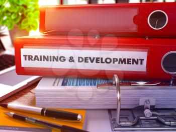 Training and Development - Red Ring Binder on Office Desktop with Office Supplies and Modern Laptop. Training and Development Business Concept on Blurred Background. 3D Render.