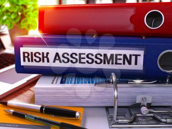 Risk Assessment - Blue Office Folder on Background of Working Table with Stationery and Laptop. Risk Assessment Business Concept on Blurred Background. Risk Assessment Toned Image. 3D.