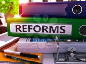 Reforms - Green Office Folder on Background of Working Table with Stationery and Laptop. Reforms Business Concept on Blurred Background. Reforms Toned Image. 3D.