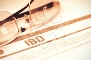 IBD - Inflammatory Bowel Disease - Printed Diagnosis with Blurred Text on Red Background with Glasses. Medical Concept. 3D Rendering.