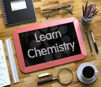 Learn Chemistry Handwritten on Small Chalkboard. Learn Chemistry Handwritten on Red Chalkboard. Top View Composition with Small Chalkboard on Working Table with Office Supplies Around. 3d Rendering.