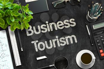 Business Tourism - Black Chalkboard with Hand Drawn Text and Stationery. Top View. 3d Rendering. Toned Image.