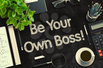 Be Your Own Boss Handwritten on Black Chalkboard. Top View of Black Office Desk with a Lot of Business and Office Supplies on It. 3d Rendering. Toned Image.