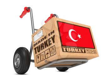 Cardboard Box with Flag of Turkey and Made in Turkey Slogan on Hand Truck White Background. Free Shipping Concept.