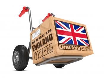 Cardboard Box with Flag of United Kingdom and Made in England Slogan on Hand Truck White Background. Free Shipping Concept.