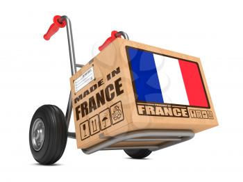 Cardboard Box with Flag of France and Made in France Slogan on Hand Truck White Background. Free Shipping Concept.