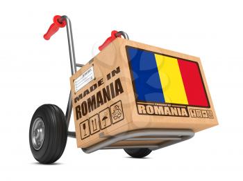 Cardboard Box with Flag of Romania and Made in Romania Slogan on Hand Truck White Background. Free Shipping Concept.