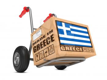 Cardboard Box with Flag of Greece and Made in Greece Slogan on Hand Truck White Background. Free Shipping Concept.