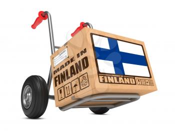Cardboard Box with Flag of Finland and Made in Finland Slogan on Hand Truck White Background. Free Shipping Concept.
