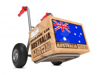 Cardboard Box with Flag of Australia and Made in Australia Slogan on Hand Truck White Background. Free Shipping Concept.
