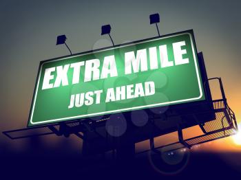 Extra Mile Just Ahead - Green Billboard on the Rising Sun Background.