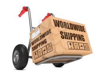 Cardboard Box with Worldwide Shipping Slogan on Hand Truck White Background.