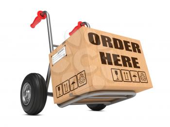 Cardboard Box with Order Here Slogan on Hand Truck Isolated on White.