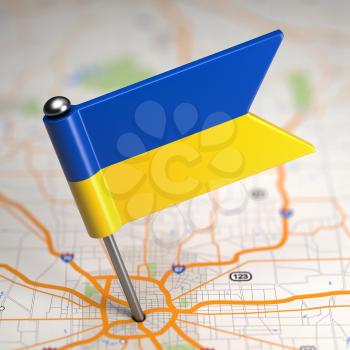 Small Flag of Ukraine Sticked in the Map Background with Selective Focus.