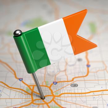 Small Flag of Ireland Sticked in the Map Background with Selective Focus.
