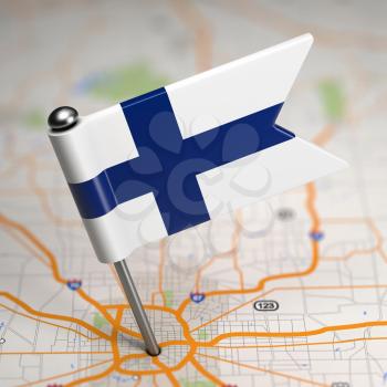 Small Flag of Republic of Finland on a Map Background with Selective Focus.