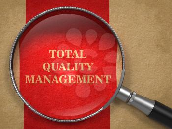 TQM -  Total Quality Management Concept. Magnifying Glass on Old Paper with Red Vertical Line Background.