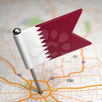 Small Flag of Qatar on a Map Background with Selective Focus.