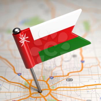Small Flag of Oman on a Map Background with Selective Focus.