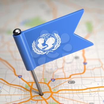 Small Flag of UNICEF on a Map Background with Selective Focus.