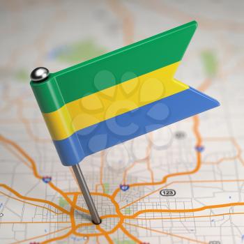 Small Flag Gabonese Republic on a Map Background with Selective Focus.