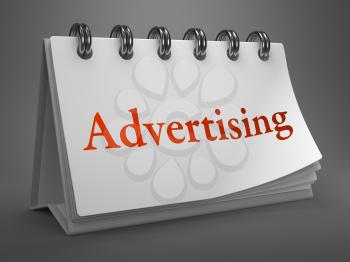 Advertising - Red Word on White Desktop Calendar Isolated on Gray Background.