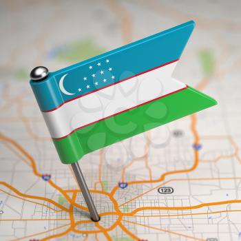 Small Flag of Uzbekistan on a Map Background with Selective Focus.