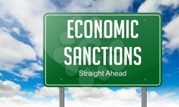 Highway Signpost with Economic Sanctions wording on Sky Background.
