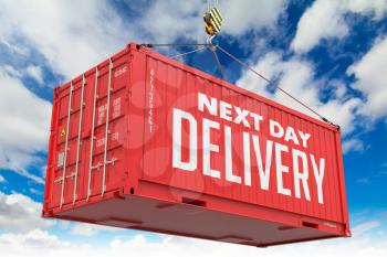 Next Day Delivery - Red Cargo Container hoisted with hook on Blue Sky Background.