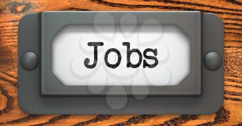 Jobs Inscription on File Drawer Label on a Wooden Background.