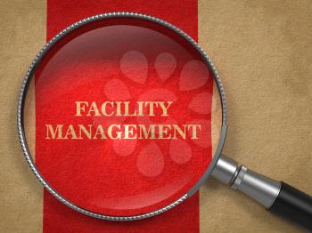 Facility Management Inscription Through Magnifying Glass on a Red Background.