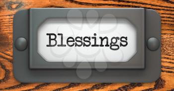 Blessing Inscription on File Drawer Label on a Wooden Background.