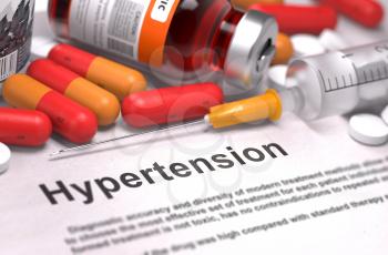 Hypertension- Printed Diagnosis with Blurred Text. On Background of Medicaments Composition - Red Pills, Injections and Syringe.
