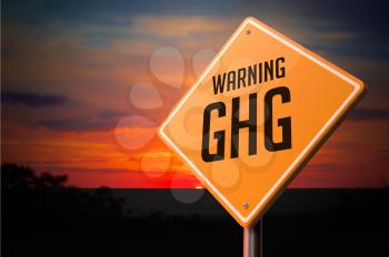 GHG on Warning Road Sign on Sunset Sky Background.