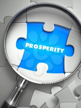 Prosperity - Word on the Place of Missing Puzzle Piece through Magnifier. Selective Focus.